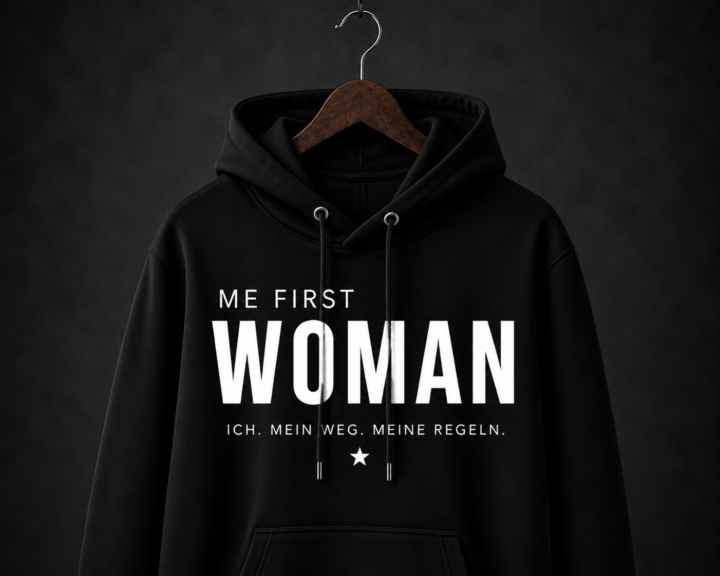 Schwarzer Damen-Statement-Hoodie mit weißem ME FIRST WOMAN Schriftzug auf dunklem Hintergrund.