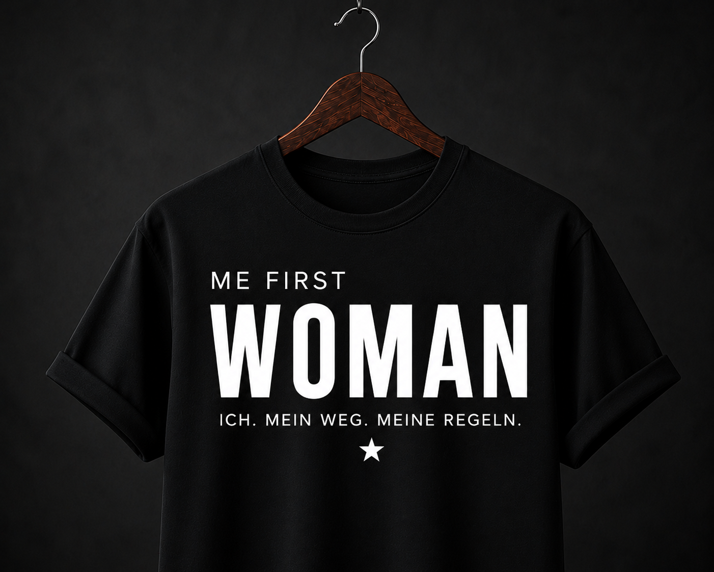 Schwarzer Damen-Statement-Shirt mit weißem ME FIRST WOMAN Schriftzug auf dunklem Hintergrund.