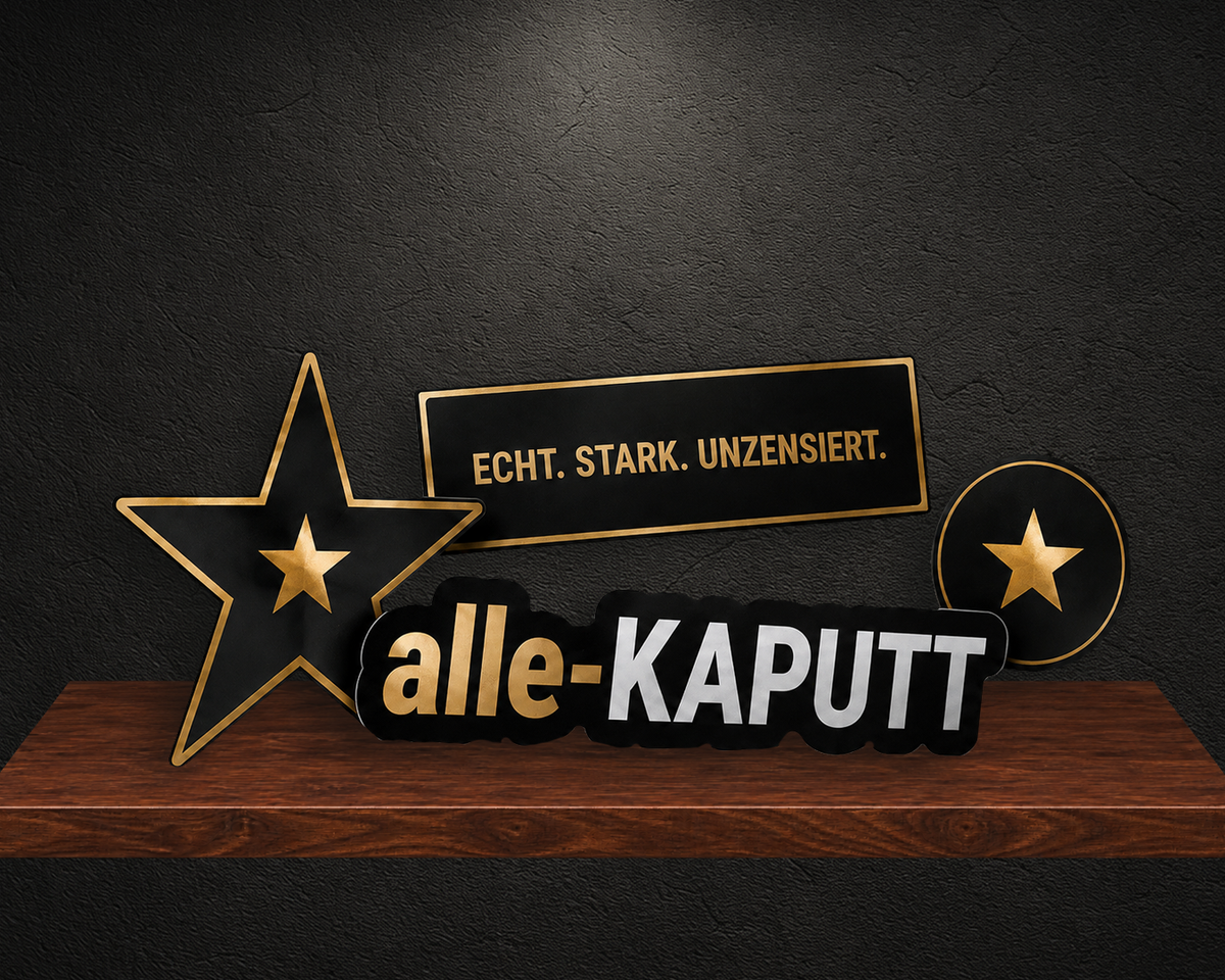 Schwarze und goldene alle-KAPUTT Sticker mit Sternen und den Schriftzügen ECHT. STARK. UNZENSIERT. und ATTITÜDE ZUM ANZIEHEN. auf einem dunkelbraunen Holzregal