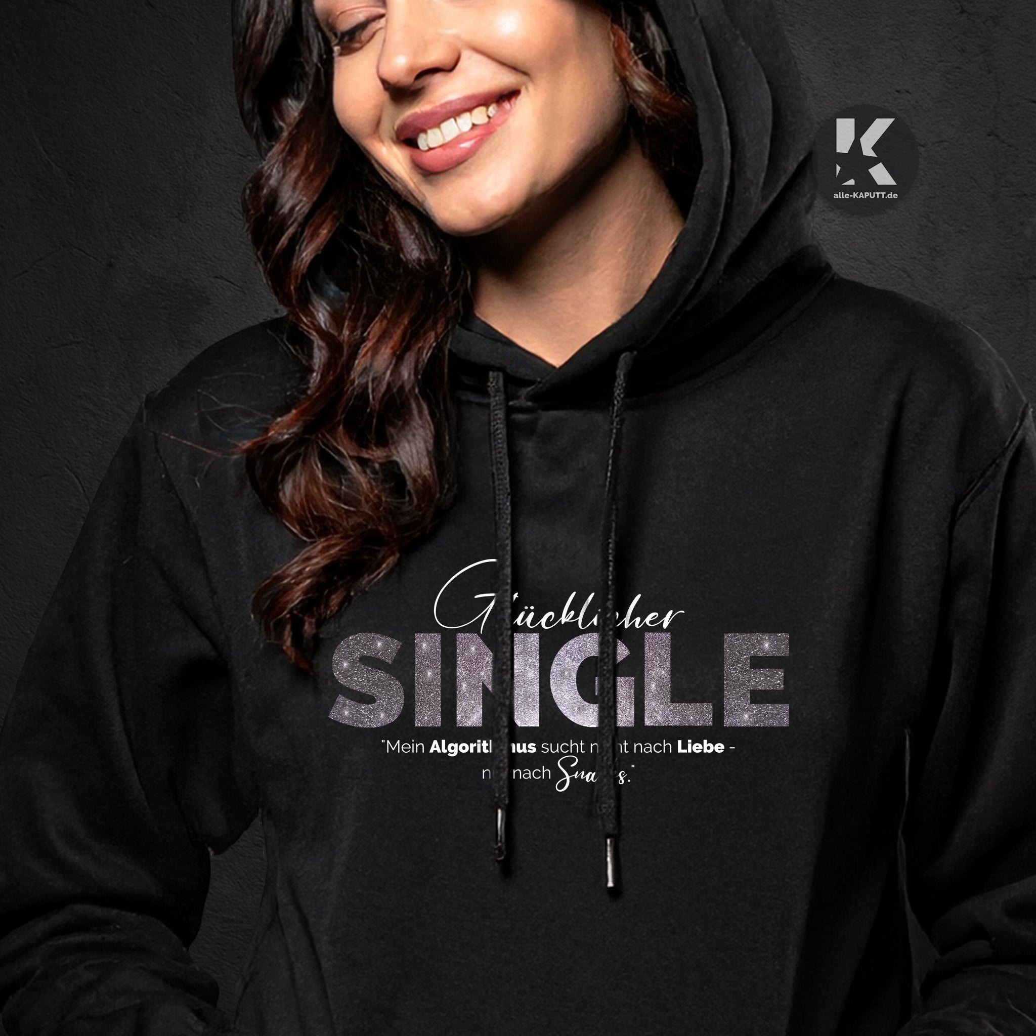 Modell trägt den alle-KAPUTT Hoodie „Algorithmus“ aus der Shiny-Single Collection – schwarzer Premium-Hoodie mit silbernem Glitzer-Print und dem Satz „Mein Algorithmus sucht nicht nach Liebe – nur nach Snacks.“