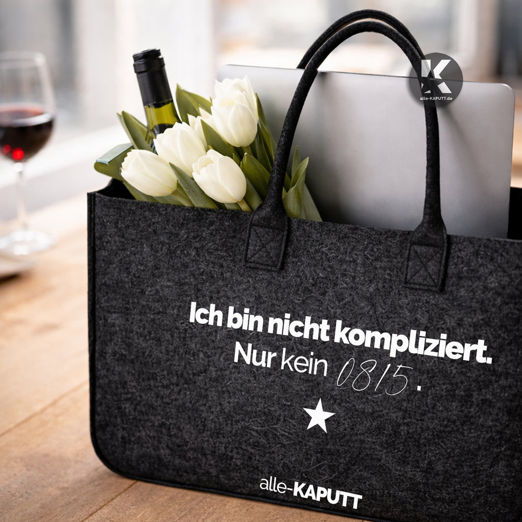 Schwarze Filztasche mit Statement „Ich bin nicht kompliziert. Nur kein 0815.“ gefüllt mit weißen Tulpen und Laptop auf einem Tisch, modernes Lifestyle-Setting.