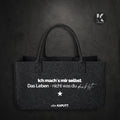 Schwarze Filztasche mit weißem Statement „Ich mach’s mir selbst. Das Leben – nicht was du denkst.“ getragen von Frauen mit Haltung, Marke alle-KAPUTT.